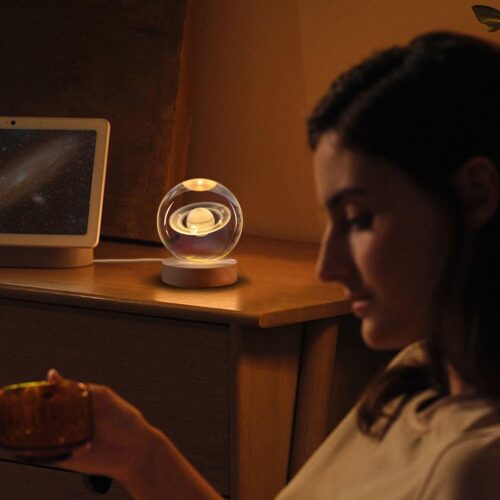Luz nocturna LED con diseño de bola de cristal 3D mostrando el planeta Saturno, perfecta para decorar mesillas de noche y crear un ambiente cálido y relajante.